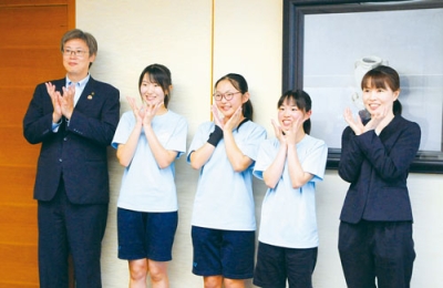 写真：デイジーズのポーズをつくり笑顔を見せるメンバーと堀井市長