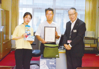写真：川上参事（右）から熱中症予防グッズを受け取った横山校長（中央）ら
