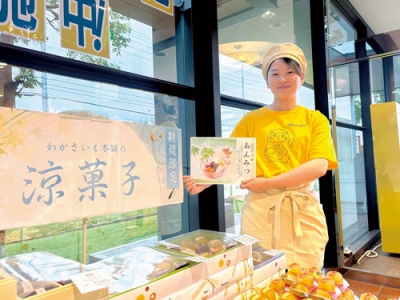 写真：人気キャラクター「はこすくん」のＴシャツであんみつをＰＲする福井さん