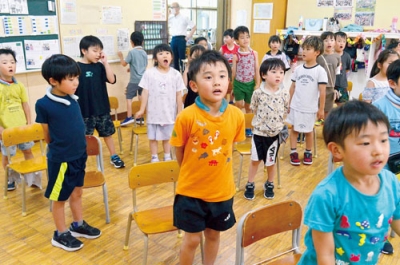 写真：リモート終業式で校歌を元気いっぱいに歌う児童たち