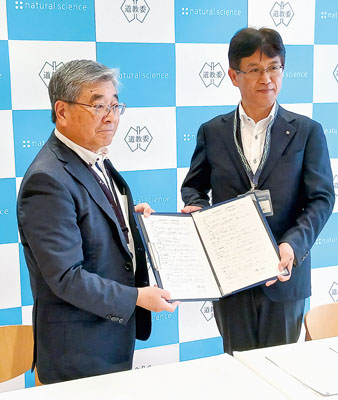 写真：協定に署名した高畠支店長（左）と髙橋局長