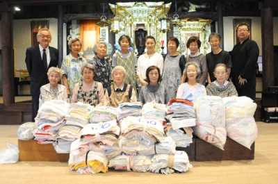 写真：３３００枚の清拭布を寄贈した本教寺の高倉住職（右端）ら