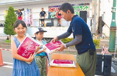 写真：「のぼりべつ夏祭り×登別ブランドまるしぇ２０２５」の大抽選会で景品を受け取る当選者