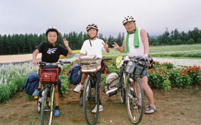 写真：４０回目の旅で、道央など約９９０キロを走った多田羅等さん（右）と小学生＝２０１７年８月、富良野市の麓郷展望台