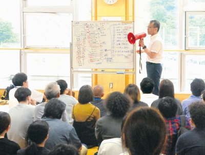 写真：室蘭西中学校の災害対策本部で職員を前に今後の対応について説明する奈良副市長