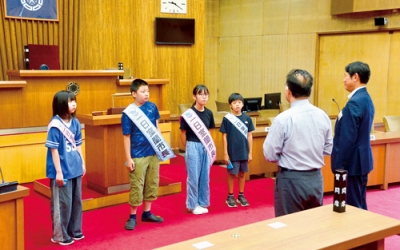 写真：議場で議会の役割について学ぶ一日市長の小学生４人
