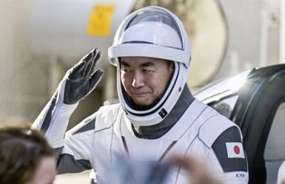 写真：見送りの家族らにあいさつし、宇宙船に向かう油井亀美也飛行士＝１日、米フロリダ州のケネディ宇宙センター（ロイター＝共同）