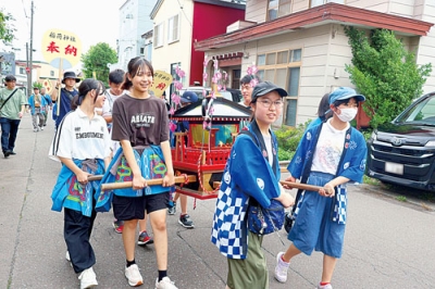 写真：地域の仲間と協力してみこしを担いだ子どもたち（提供写真）