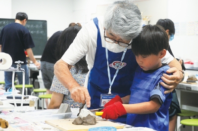 写真：道具を使って化石を探す児童