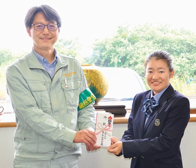 写真：ヨットの尾形選手に寄付の目録を手渡す染谷所長（左）
