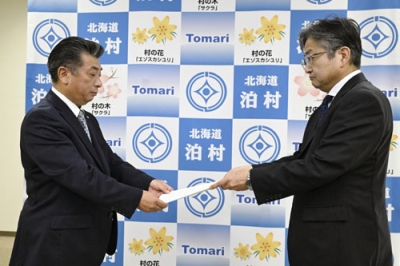 写真：資源エネルギー庁幹部から北電泊原発３号機の再稼働に関する文書を受け取る泊村の高橋鉄徳村長（左）＝４日午前、泊村役場