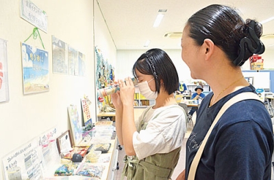 写真：展示物の手作り万華鏡を楽しむ来場者
