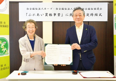 写真：協定を手交した岡澤理事長（左）と仲川会長