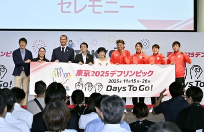 写真：「東京デフリンピック」開幕１００日前セレモニーで記念写真に納まる関係者。中央は小池百合子都知事＝７日午前、東京都内