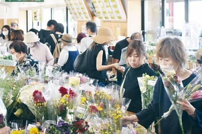 写真：盆の入りを前に新鮮な花や野菜を求める買い物客でにぎわう伊達市観光物産館