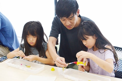 写真：ＵＶビーズキーホルダー作りを楽しむ親子