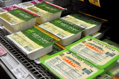 写真：ハワイ・ホノルルのスーパーに並ぶ「アロハ豆腐ファクトリー」の絹ごし豆腐（手前）。奥は同社が手がけたプライベートブランドの豆腐＝６月（共同）
