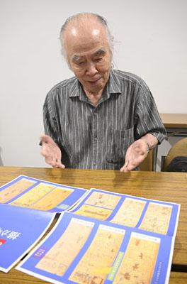 写真：戦争末期に掲載されていた「のらくろ」を読む漫画家の山根青鬼さん＝東京都江東区