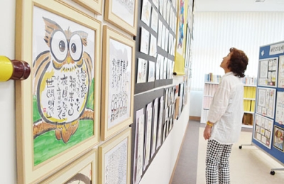 写真：温かみのある色使いの己書約２００点が並ぶ