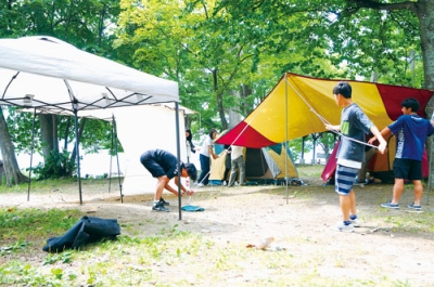 写真：協力しながらテントを組み立てるキャンパー＝１４日午後、仲洞爺キャンプ場