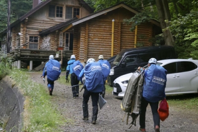 写真：羅臼岳登山口に向かう捜索隊＝１５日午前４時４３分、斜里町