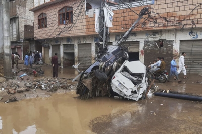 写真：豪雨による洪水で流され、電柱に衝突した車＝１５日、パキスタン北西部ミンゴラ近郊（ＡＰ＝共同）