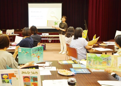 写真：絵本を読み聞かせる際の持ち方を指導する森さん