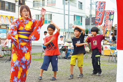 写真：輪になって踊る市民＝１６日午後６時半ごろ、室蘭市中島町のお元気広場