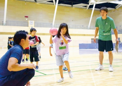 写真：須田さん（右）の指導でハンドボールを楽しむ子どもたち