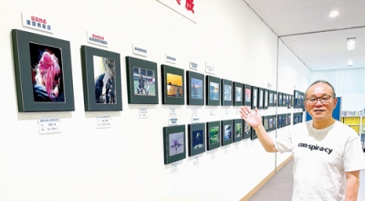 写真：力作４１点をバックに来場を呼びかける鳥海事務局長