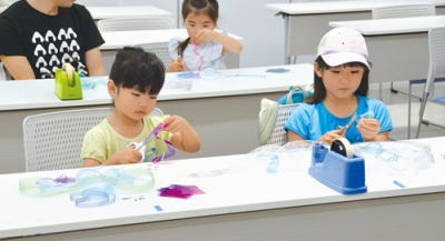 写真：協力してクラゲのモビールを作る親子ら