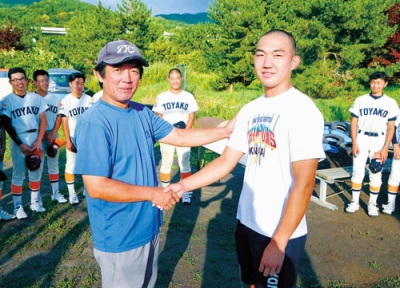 写真：恩師である若松監督と握手を交わす石垣投手＝１７日夕、洞爺湖町内