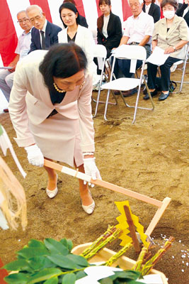 写真：地鎮祭でくわ入れする杉山理事長