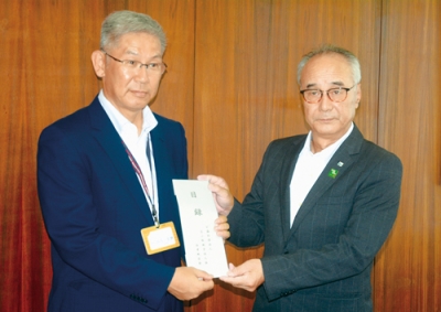 写真：目録を手渡す清水会長（右）と井内教育長