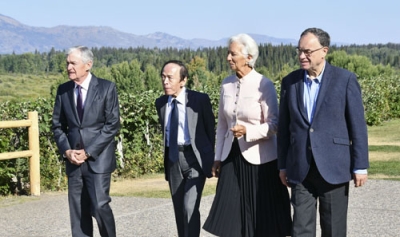 写真：ジャクソンホール会合の会場で言葉を交わすＦＲＢのパウエル議長（左端）、日銀の植田総裁（左から２人目）ら＝２２日、米ワイオミング州（共同）