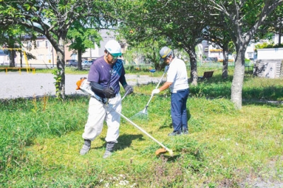 写真：寿２丁目公園で草刈り作業に励む建設３社の社員