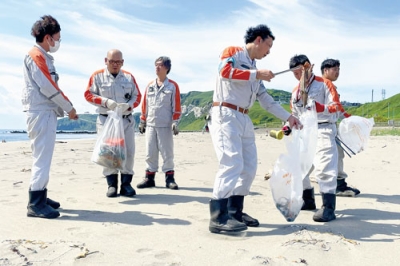 写真：イタンキ浜でごみ拾いに汗を流す幌清の社員