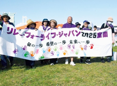 写真：がん征圧の願いを込めて歩みを進める参加者たち＝２３日午後２時５０分ごろ、道の駅カナスチールみたら室蘭横広場