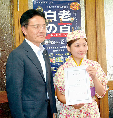写真：観光大使に任命された小瀧さん（右）と大塩町長