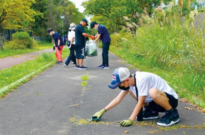 写真：学校周辺で環境美化活動に取り組む高等部の生徒ら