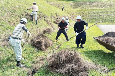 写真：草刈り作業に汗を流す高橋建設の社員ら（提供写真）