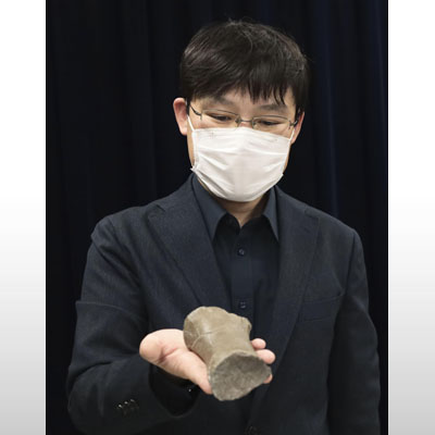 写真：新属新種のセミクジラの一種と判明したクジラの化石を手にする札幌市博物館活動センターの田中嘉寛学芸員＝２６日午後、札幌市役所