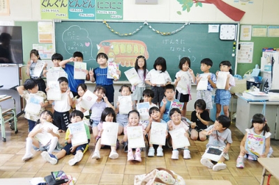 写真：夏休みの宿題や絵日記を手にする子どもたち