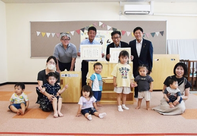 写真：幼児らにお披露目された流し台と冷蔵庫の玩具
