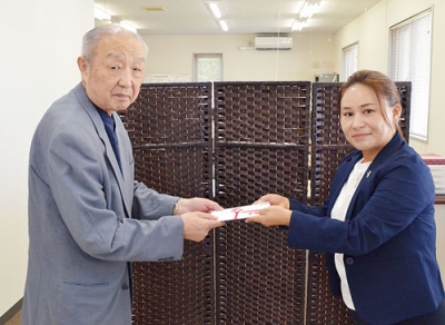写真：寄付の目録を手渡す田中代表取締役（右）と佐々木会長