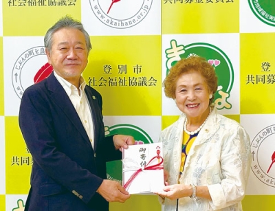 写真：仲川会長（左）に寄付金を手渡す佃さん（右）