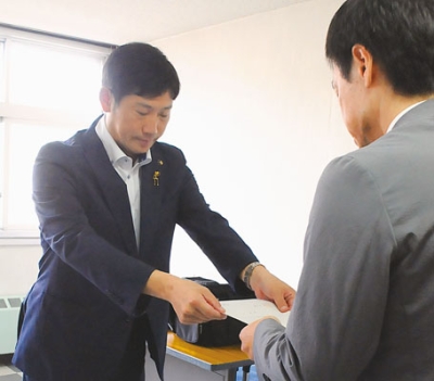 写真：市村会長に諮問する青山市長（左）