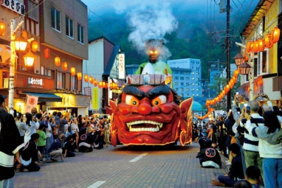 写真：煙を上げながら地獄の審判を下すエンマ大王からくり山車＝３０日午後６時１０分、登別温泉極楽通り