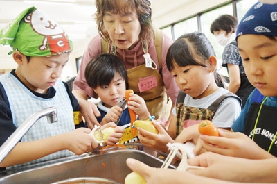写真：カレーの材料を真剣な表情で下準備する子どもたち