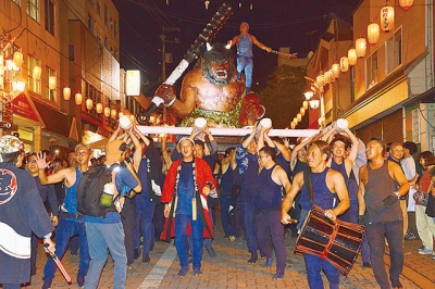 写真：約１トンのみこしを１００人の男衆が担いだ鬼みこし暴れ練りこみ＝３０日午後８時１５分、極楽通り